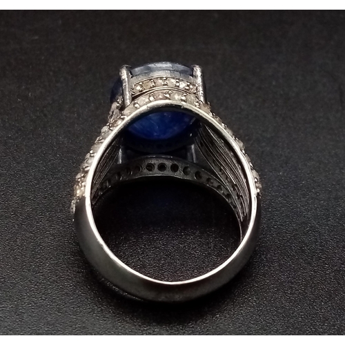 628 - An 8.70ct Blue Sapphire Ring - with 1.55ct of Diamond Accents. Set in 925 Silver. Size M. 7.3g total... 