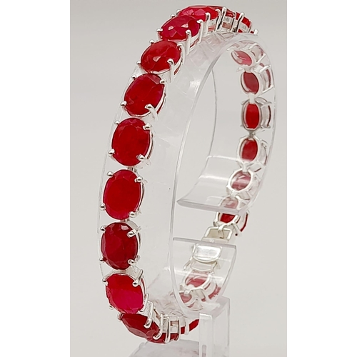 633 - A Ruby Gemstone Tennis Bracelet set in 925 Silver. 20 oval cut rubies. 19cm. 21g total weight.