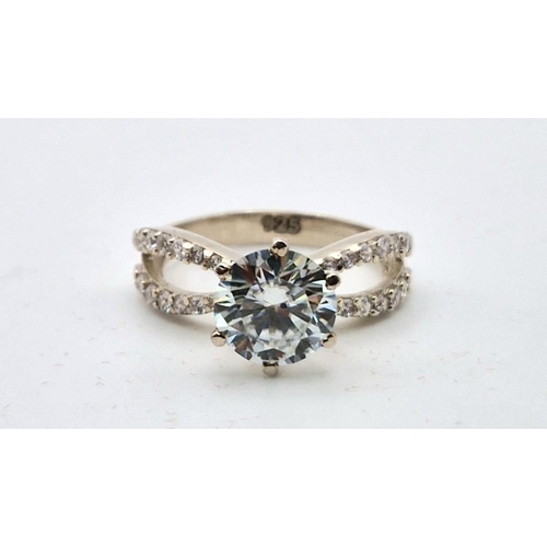 610 - A 2ct White Moissanite Crossover Ring with White Stone Accents. Set in 925 Silver. Size N. Comes in ... 