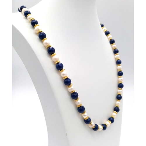 455 - A Lapis Lazuli and Cultured Pearl Matinee Necklace. 70cm. Gold plated spacers and clasp.