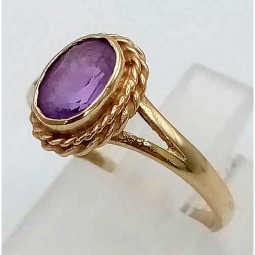 566 - A Vintage Amethyst 9K Yellow Gold Ring. Oval cut amethyst in a scroll decorative setting. Size L. 1.... 