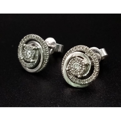 1186 - A Pair of 9K White Gold and Diamond Swirl-Stud Earrings. 1.67g total weight. Ref: 53