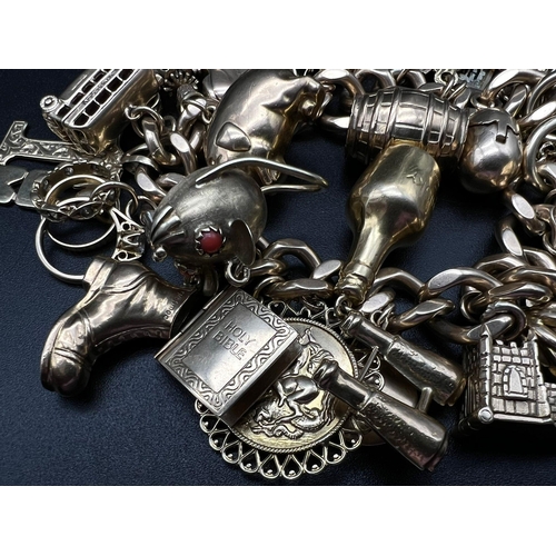 450 - A Huge 9K Gold Charm Bracelet with Heart Clasp. 32 Eclectic pieces will intrigue the most avid charm... 