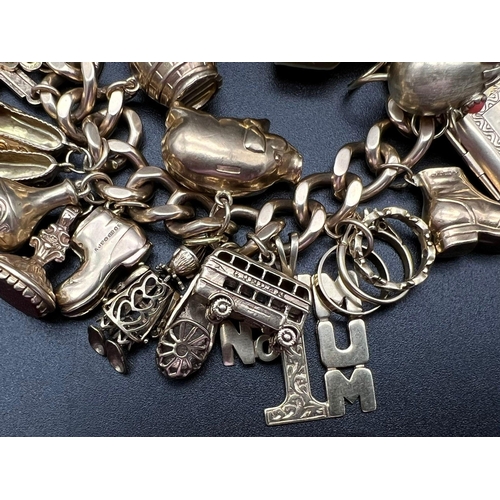 450 - A Huge 9K Gold Charm Bracelet with Heart Clasp. 32 Eclectic pieces will intrigue the most avid charm... 