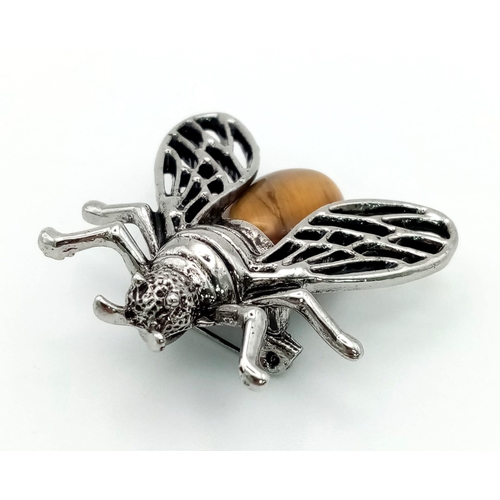 465 - A Tigers Eye Cicada Brooch. Set in white metal. 4cm x 3.5cm wingspan.