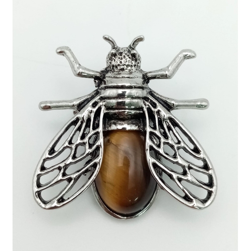 465 - A Tigers Eye Cicada Brooch. Set in white metal. 4cm x 3.5cm wingspan.