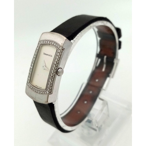 408 - A Tiffany and Co 18K Gold and Diamond Ladies Watch. Black leather strap with Tiffany white gold and ... 