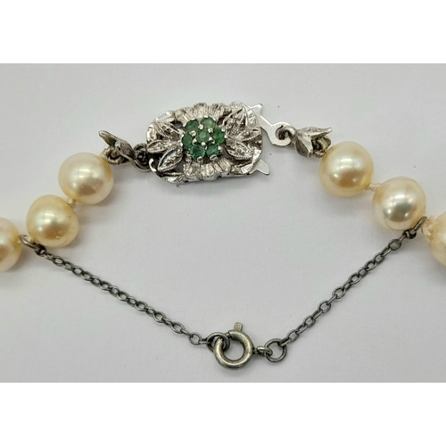 717 - A Cultured South Sea Pearl Necklace with an 18K White Gold and Emerald Clasp. 50cm