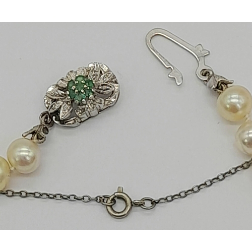 717 - A Cultured South Sea Pearl Necklace with an 18K White Gold and Emerald Clasp. 50cm