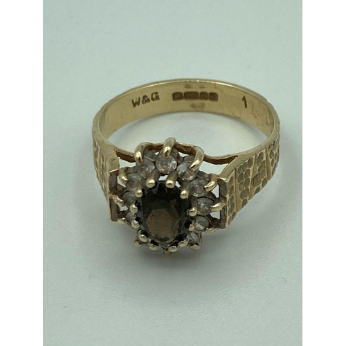 125 - 9 carat GOLD RING. Having dark blue Tourmaline Gemstone set to top with white Topaz surround. Attrac... 