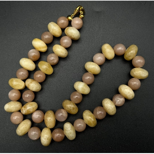 452 - A Honey Jade and Peach Moonstone Bead Necklace. Rondelle honey beads with circular peach moonstones.... 