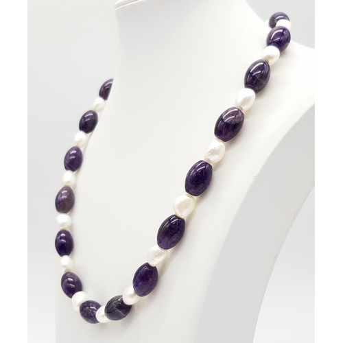 515 - A Sophisticated Amethyst and Baroque Pearl Necklace. Elongated amethyst 12mm beads with cultured bar... 