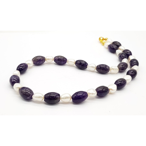 515 - A Sophisticated Amethyst and Baroque Pearl Necklace. Elongated amethyst 12mm beads with cultured bar... 