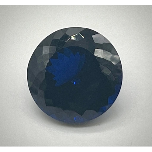 529 - A 36ct Round Cut Dark Blue Gemstone. Well-faceted. 20mm upper diameter. No certificate so a/f.