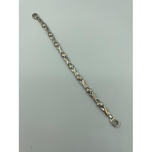 70 - 9 carat WHITE GOLD BRACELET With yellow gold detail,having attractive crossover links in a modernist... 