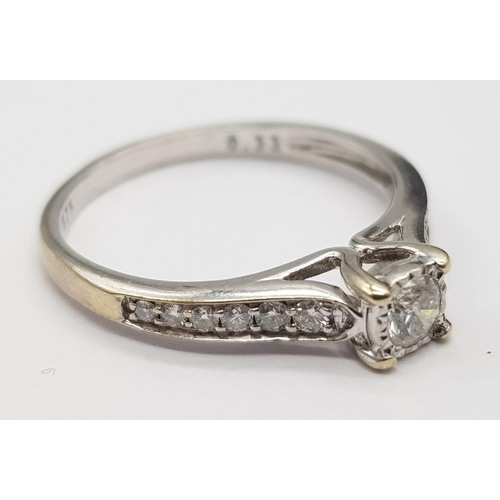 654 - A 9K White Gold Diamond Ring. 0.33ct. Central round cut diamond with complimentary smaller diamonds ... 