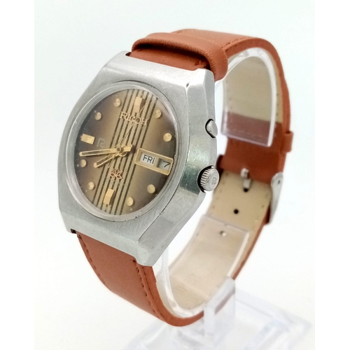 1141 - A Ricoh Automatic 21 Jewel Gents Watch. Brown leather strap and stainless steel case - 37mm. Gold to... 