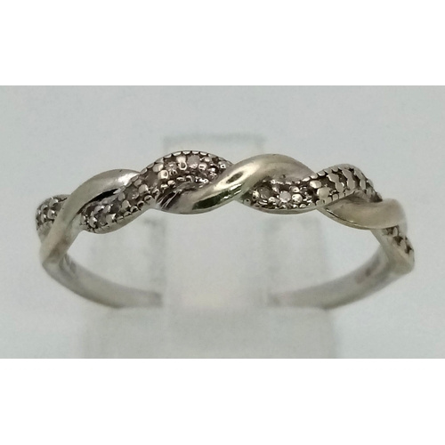 401 - A 9K White Gold Diamond Twist Ring. Size Q. 1.93g total weight.