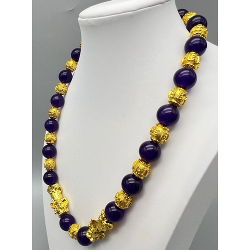 161 - A Chinese deep purple jade necklace and earrings set with 22 K yellow gold gilded feng shui beads an... 