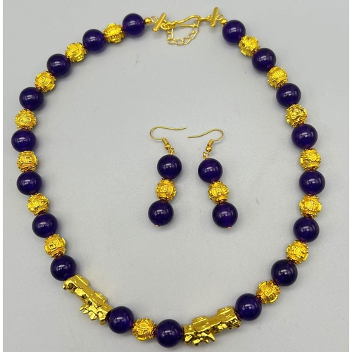 161 - A Chinese deep purple jade necklace and earrings set with 22 K yellow gold gilded feng shui beads an... 