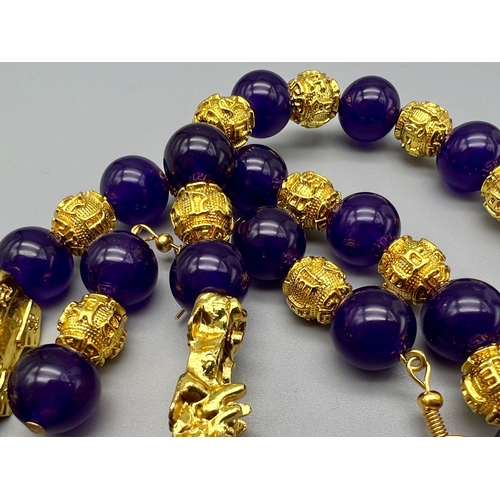 161 - A Chinese deep purple jade necklace and earrings set with 22 K yellow gold gilded feng shui beads an... 