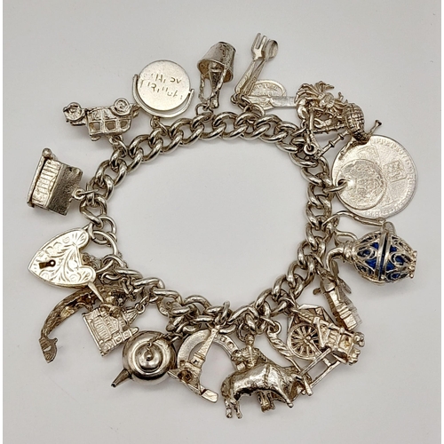 554 - A 925 Silver Charm Bracelet with an Eclectic Mix of 22 Charms. Including: Horseshoe, Eiffel Tower an... 