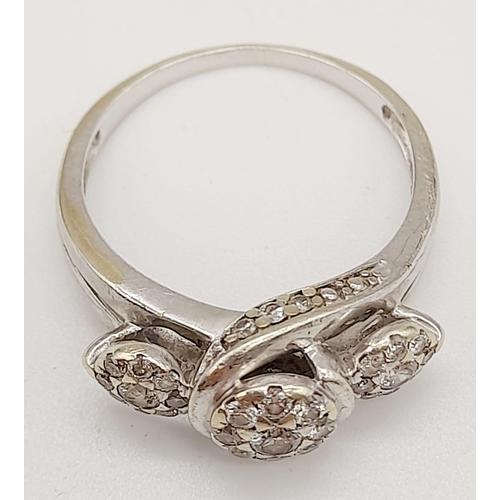 72 - A 9K White Gold Triple Diamond Cluster Ring. Three diamonds each with a halo of diamonds. Size N. 3.... 