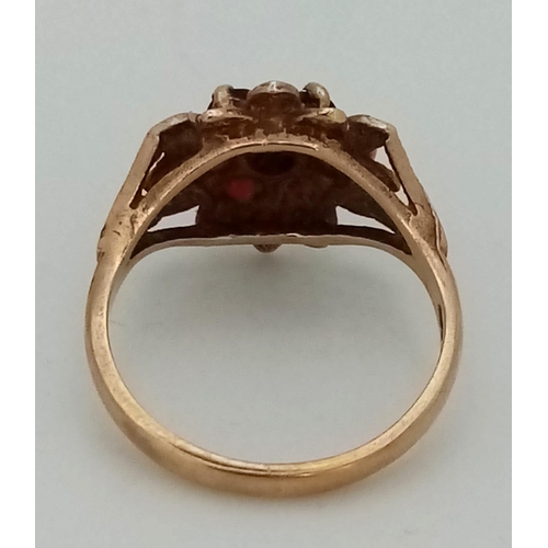 665 - A Vintage 9K Yellow Gold Garnet Ring. Floral decoration. Size K. 2.43g total weight.