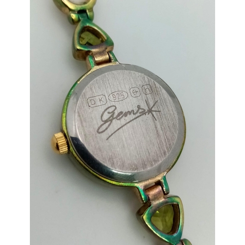 1153 - A Gems 925 Silver Quartz Ladies Watch. Pearl and peridot bracelet. MOP dial. In good condition and w... 