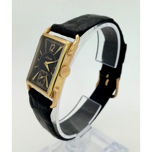 22 - A 14 K yellow gold Le Coultre watch. 27 x 20 mm case, gold bezel, black face with gold hour marks an... 