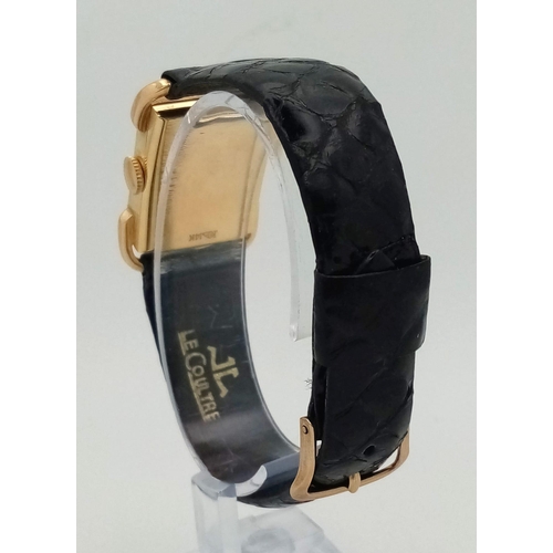 22 - A 14 K yellow gold Le Coultre watch. 27 x 20 mm case, gold bezel, black face with gold hour marks an... 