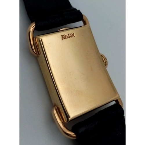 22 - A 14 K yellow gold Le Coultre watch. 27 x 20 mm case, gold bezel, black face with gold hour marks an... 