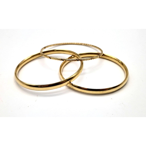 497 - An 18 K yellow gold lot consisting of two bangles with some dents and another engraved bangle. Total... 