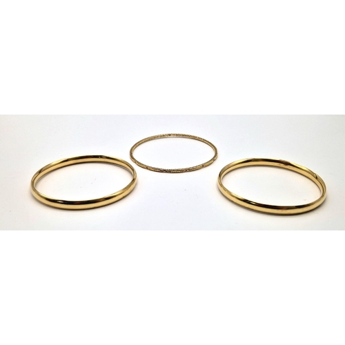 497 - An 18 K yellow gold lot consisting of two bangles with some dents and another engraved bangle. Total... 