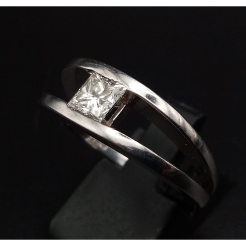 345 - An 18K White Gold Diamond Solitaire Ring. A clam-like opening presents a VS1 Princess cut 1ct diamon... 