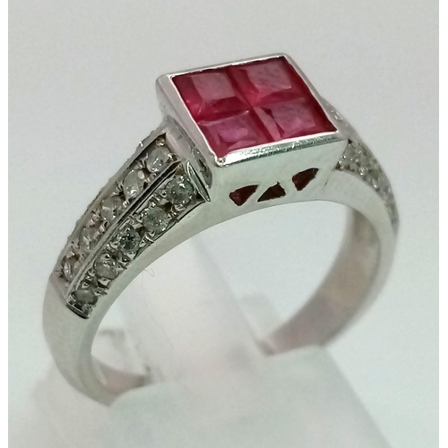 701 - An 18K White Gold Diamond and Ruby Ring. Four square-cut central rubies with a three row cluster of ... 