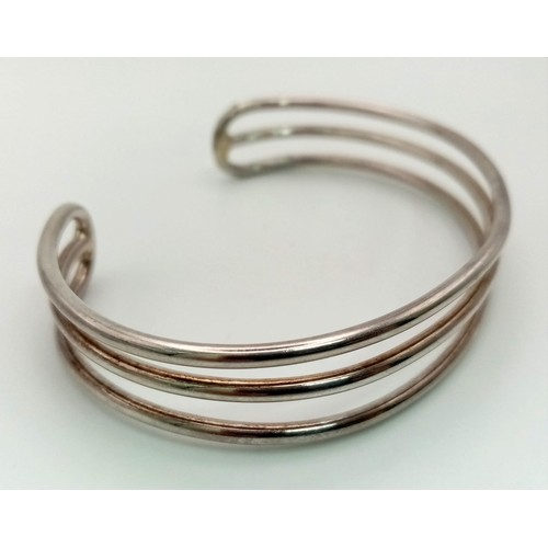 985 - A unisex, three row, sterling silver cuff bangle. Weight: 23.9 g.