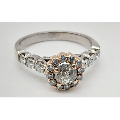 437 - An 18K White and Rose Gold Diamond Ring. A central 0.70ct diamond surrounded by a halo, wings and fo... 