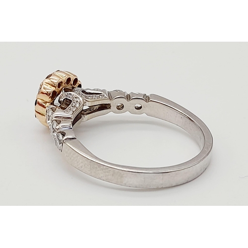 437 - An 18K White and Rose Gold Diamond Ring. A central 0.70ct diamond surrounded by a halo, wings and fo... 