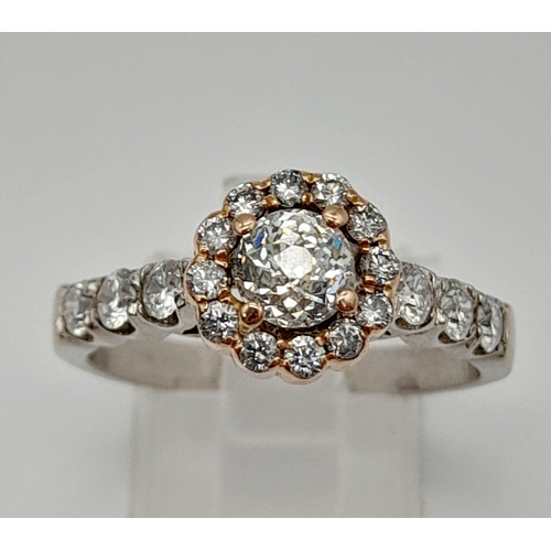 437 - An 18K White and Rose Gold Diamond Ring. A central 0.70ct diamond surrounded by a halo, wings and fo... 