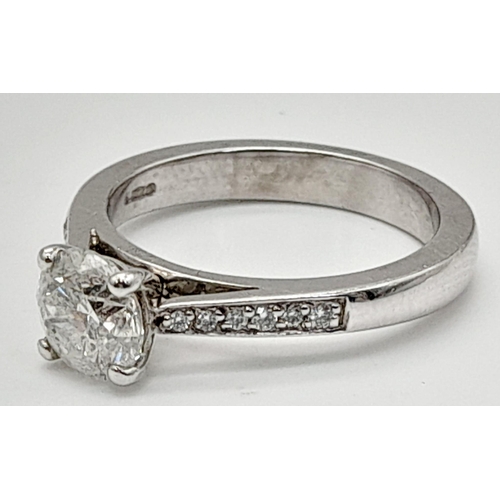 198 - A 950 Platinum Diamond Ring. A centre 1ct round cut diamond with a further 0.24ct of diamonds on sho... 