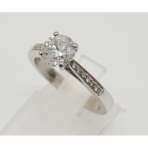 198 - A 950 Platinum Diamond Ring. A centre 1ct round cut diamond with a further 0.24ct of diamonds on sho... 