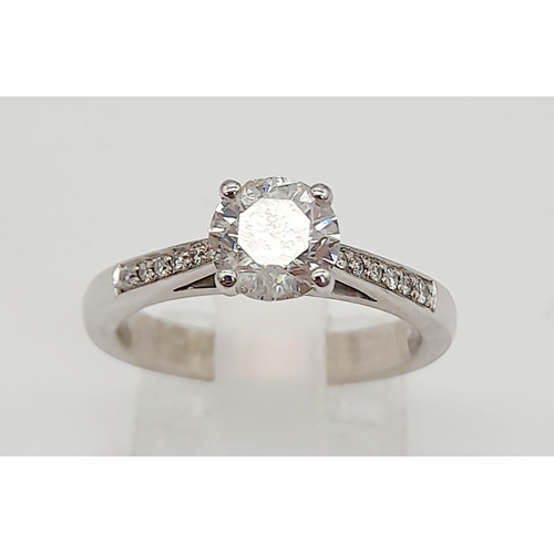 198 - A 950 Platinum Diamond Ring. A centre 1ct round cut diamond with a further 0.24ct of diamonds on sho... 