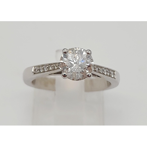 198 - A 950 Platinum Diamond Ring. A centre 1ct round cut diamond with a further 0.24ct of diamonds on sho... 