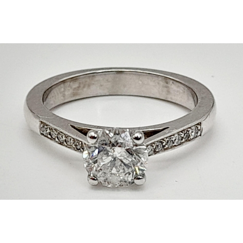 198 - A 950 Platinum Diamond Ring. A centre 1ct round cut diamond with a further 0.24ct of diamonds on sho... 