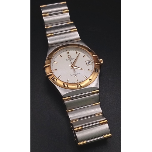 380 - An Omega Constellation Two Tone Gents Watch. Two tone strap and case - 33mm. Cream dial with date wi... 