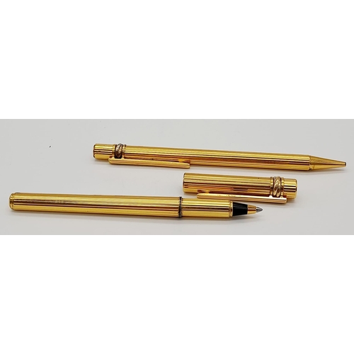 520 - A Set of Two Gold Plated Cartier Pens. A rollerball and ballpoint. Presented in a leather burgundy p... 