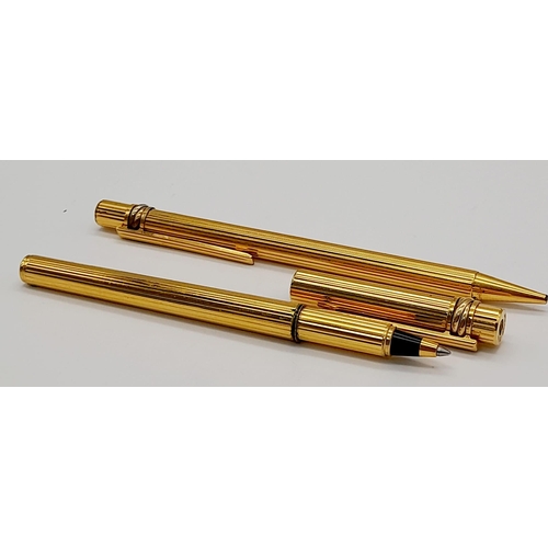 520 - A Set of Two Gold Plated Cartier Pens. A rollerball and ballpoint. Presented in a leather burgundy p... 