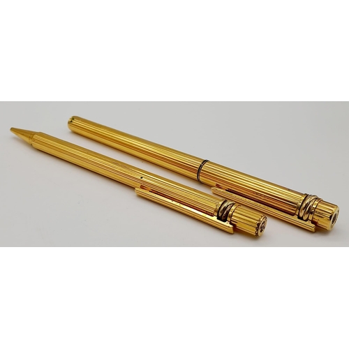 520 - A Set of Two Gold Plated Cartier Pens. A rollerball and ballpoint. Presented in a leather burgundy p... 