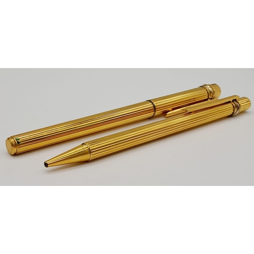 520 - A Set of Two Gold Plated Cartier Pens. A rollerball and ballpoint. Presented in a leather burgundy p... 